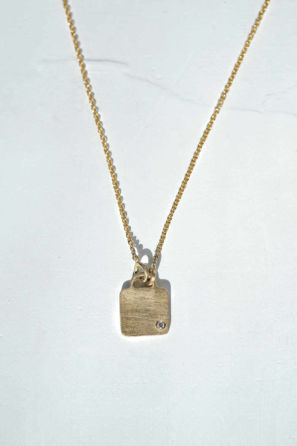 Gold Necklace With A Square Pendant Set With A Diamond