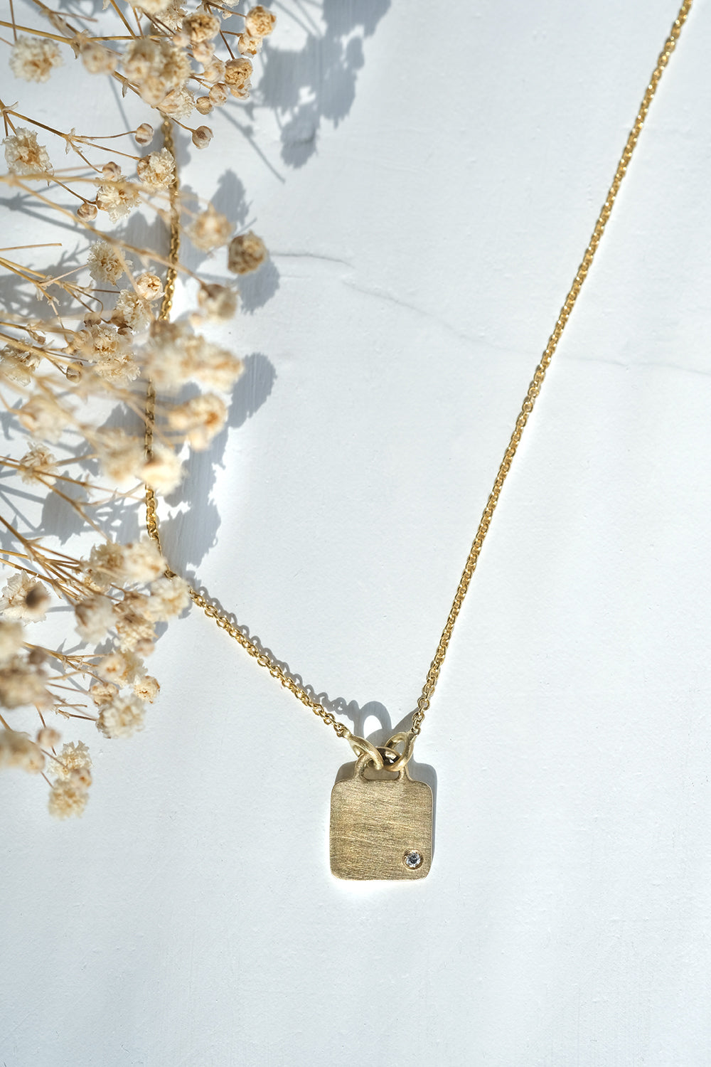 Gold Necklace With A Square Pendant Set With A Diamond
